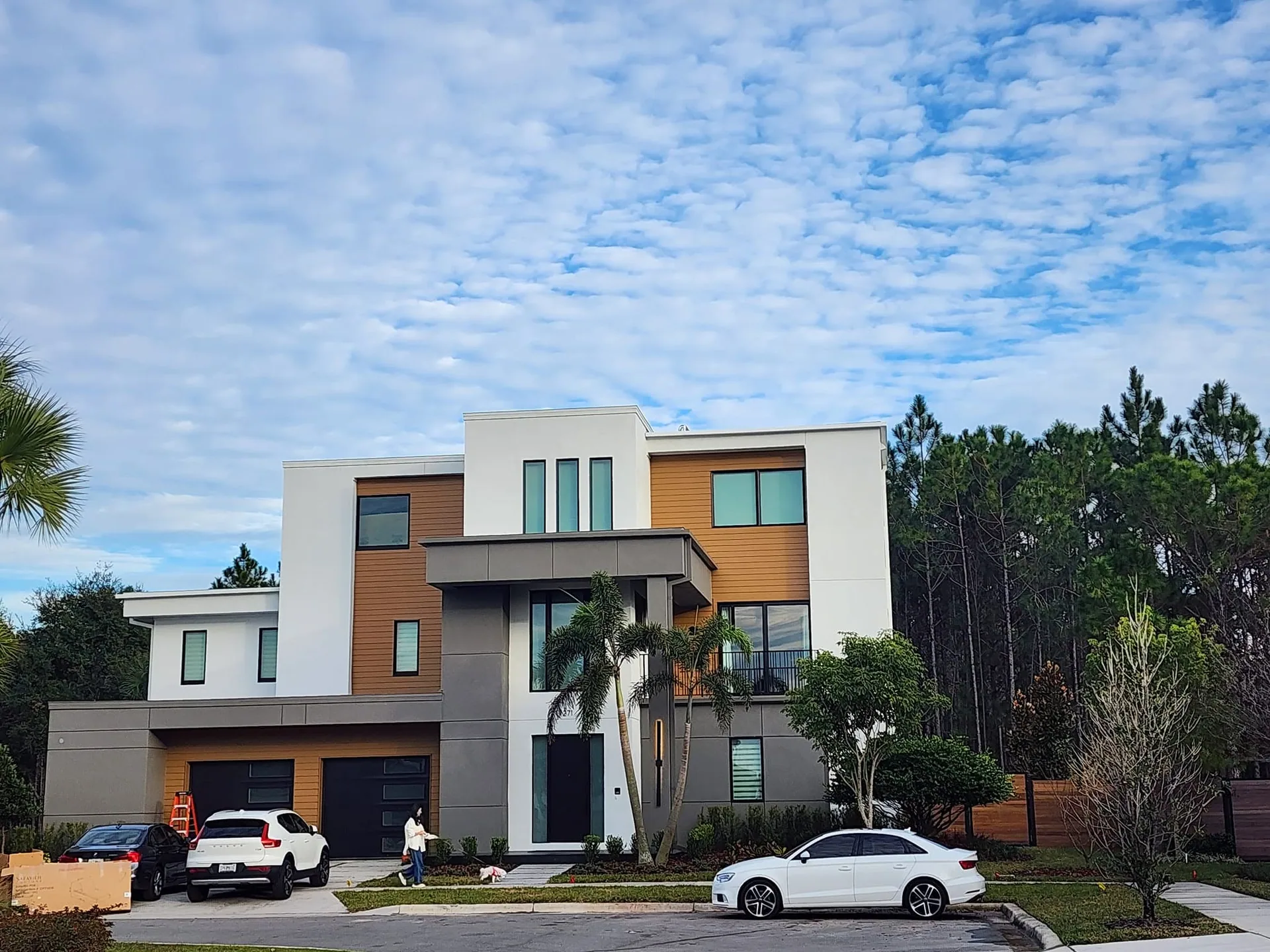 Three story flat roof wood accent modern home street view, Sanford